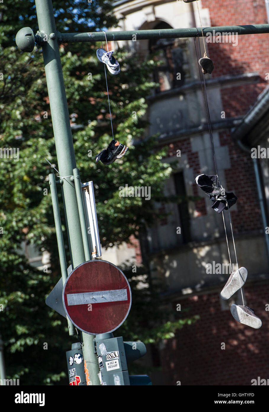Berlin, Germany. 11th Aug, 2016. Several shoes hanging from a traffic light  pole in Berlin, Germany, 11 August 2016. This is the result of so-called " shoe tossing" - a trend that is