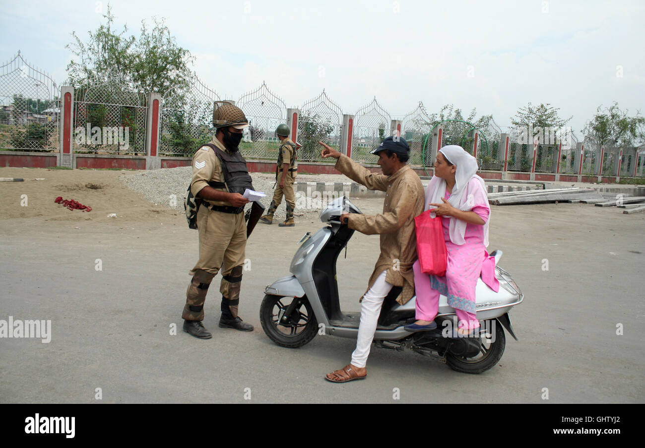 Srinagar, Indian Administered Kashmir. 11th August, 2016. Indian paramilitary soldiers stop kashmiri on a motorbike during curfew in Srinagar.Kashmir has been under a security lockdown and curfew since Violent protests have rocked Kashmir after Hizbul Mujahideen commander Burhan Wani was killed in an encounter with security forces on July 8. As many as 55 persons, including two cops, were killed and several thousand others injured in the clashes between protestors and security forces Credit: Sofi Suhail/Alamy Live News Stock Photo