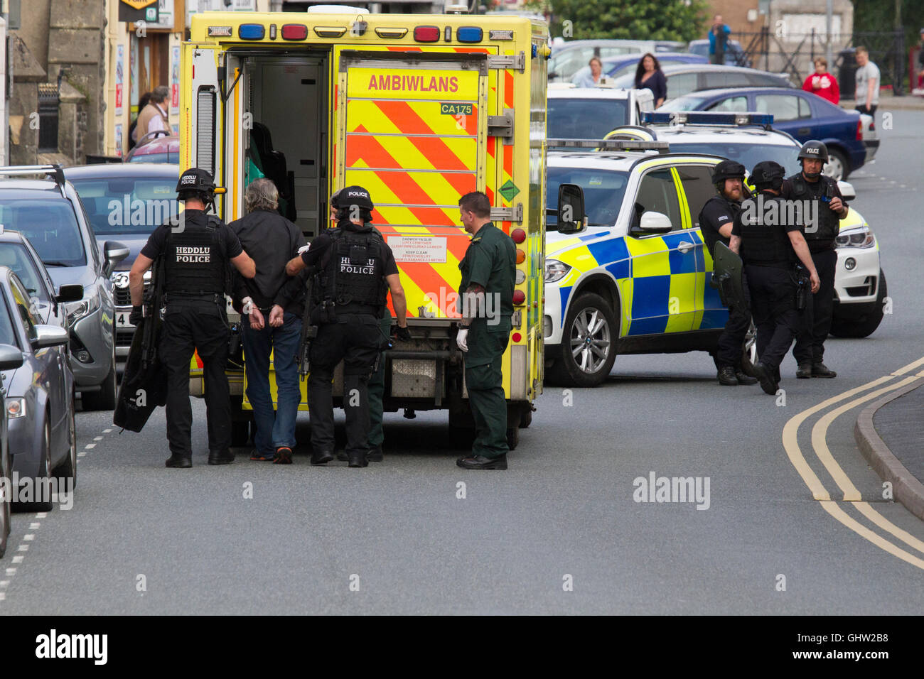 A man is arrested by police and taken to an ambulance Stock Photo