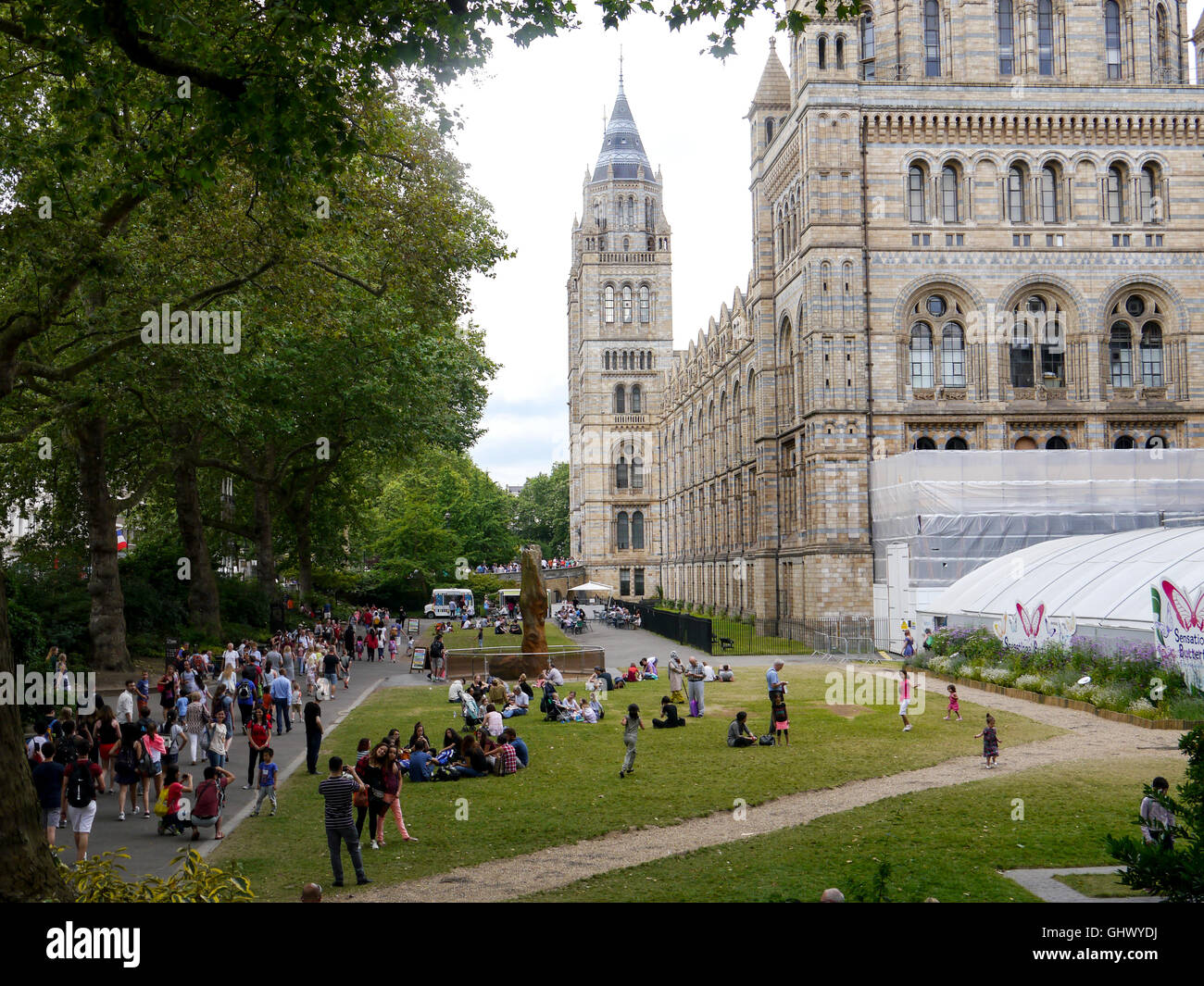 people walking and relaxing on the grass beside the Natural history museum, London, England Stock Photo