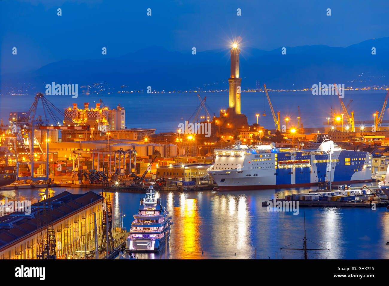Old Lighthouse in port of Genoa at night, Italy. Stock Photo