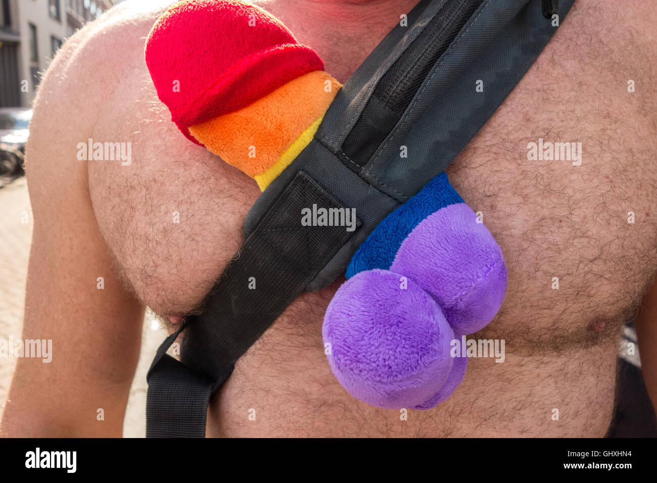 Gay Pride. Man with rainbow colored penis as a soft toy. Rainbow Willy or Plush Rainbow Dick. Gay Pride Amsterdam. Stock Photo