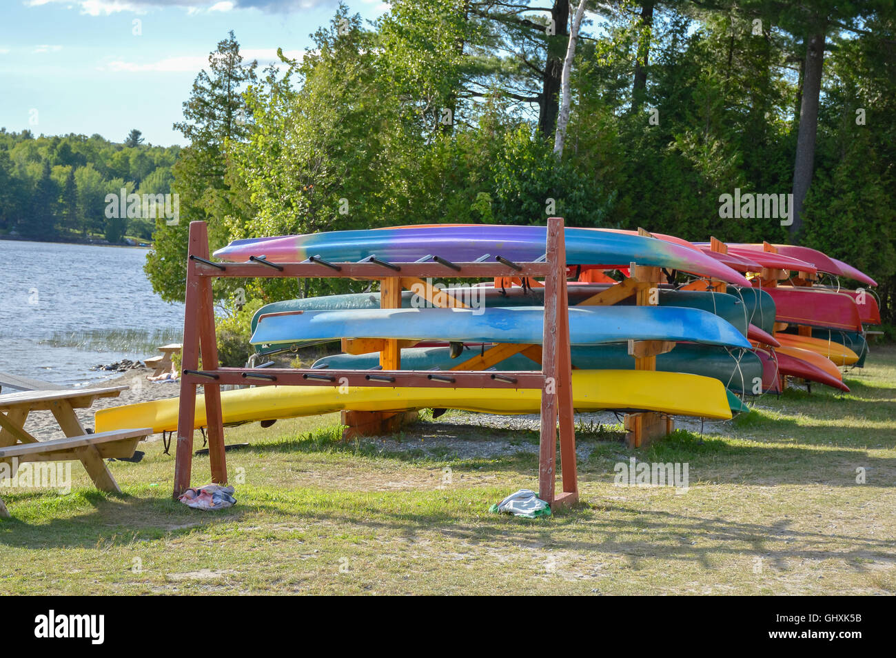 Group of canoes and kayaks on a green grass in park, Canada. Stock Photo