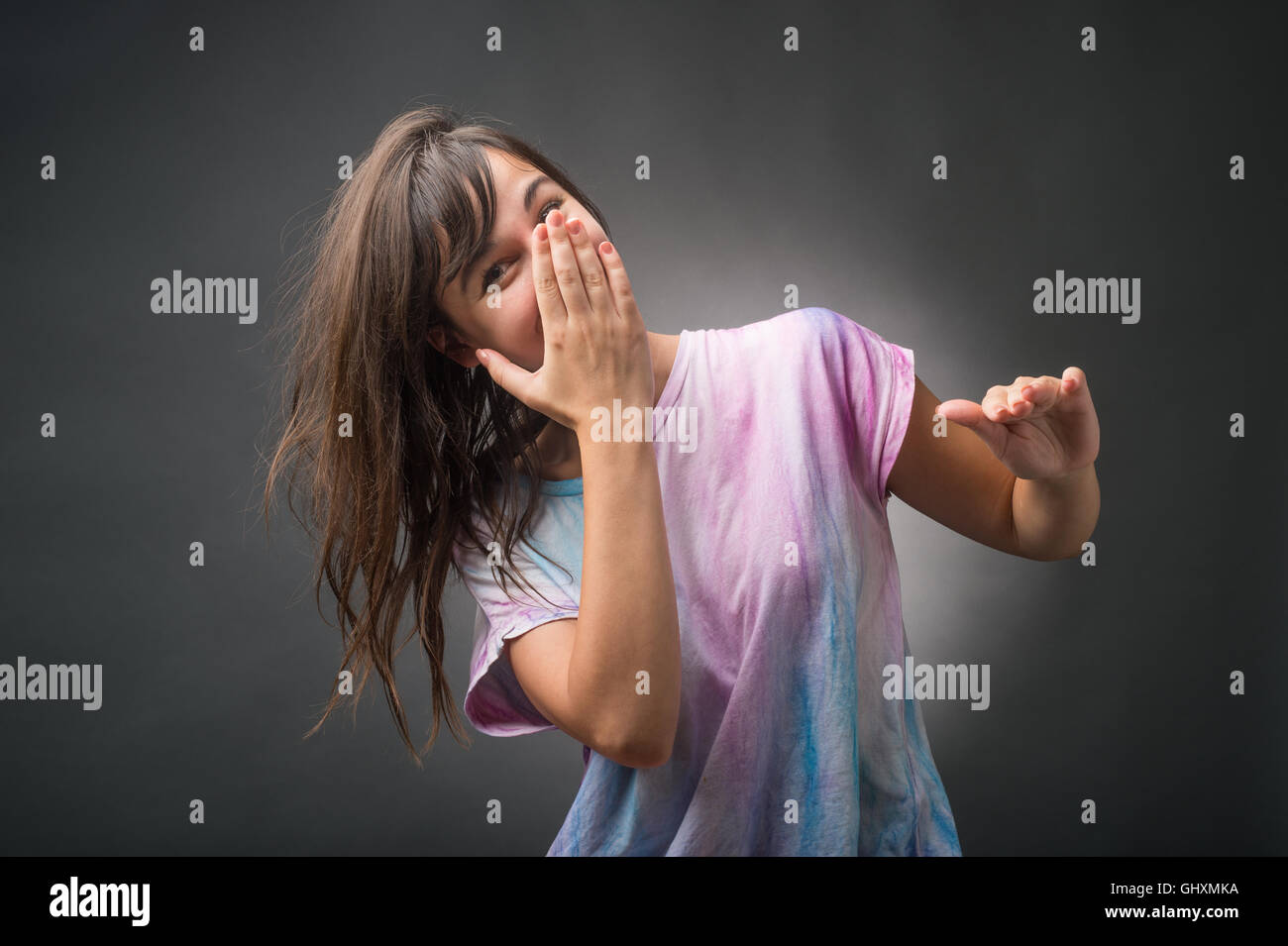 Young woman with hand over mouth Stock Photo