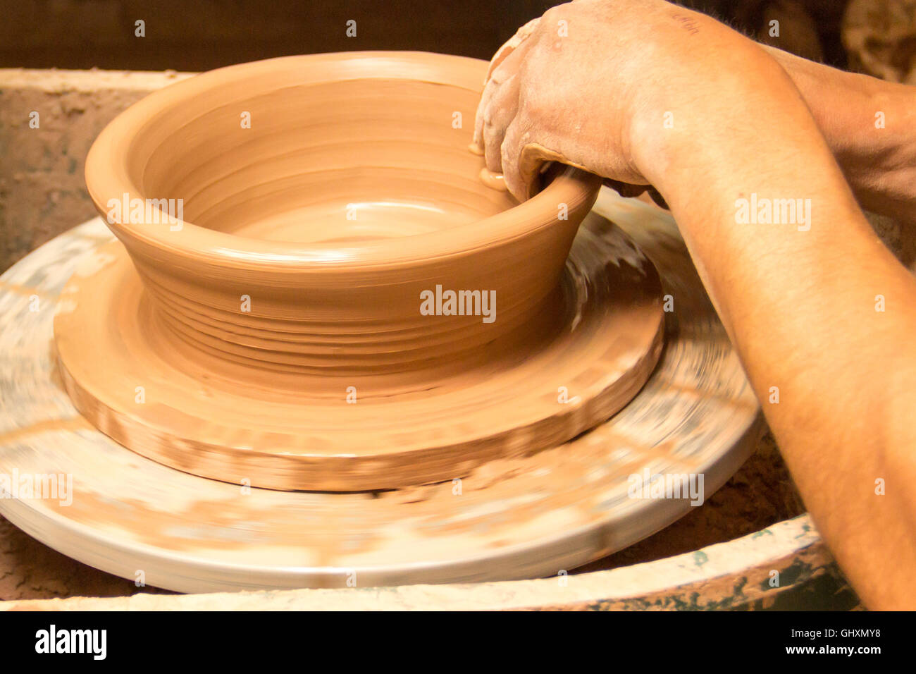 Potter at work throwing dish on potter's wheel Stock Photo Alamy