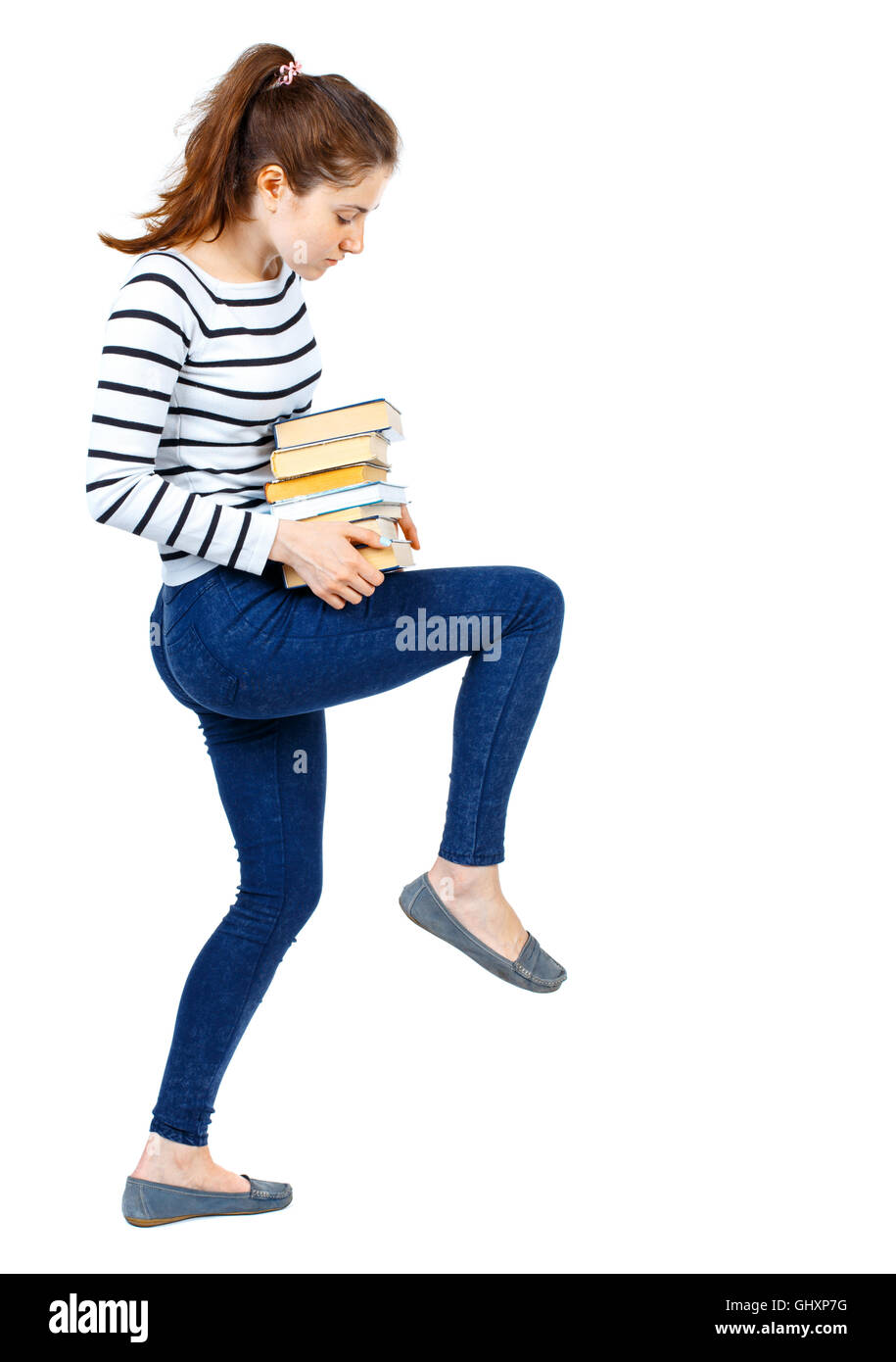 Girl carries a heavy pile of books. back view Stock Photo - Alamy