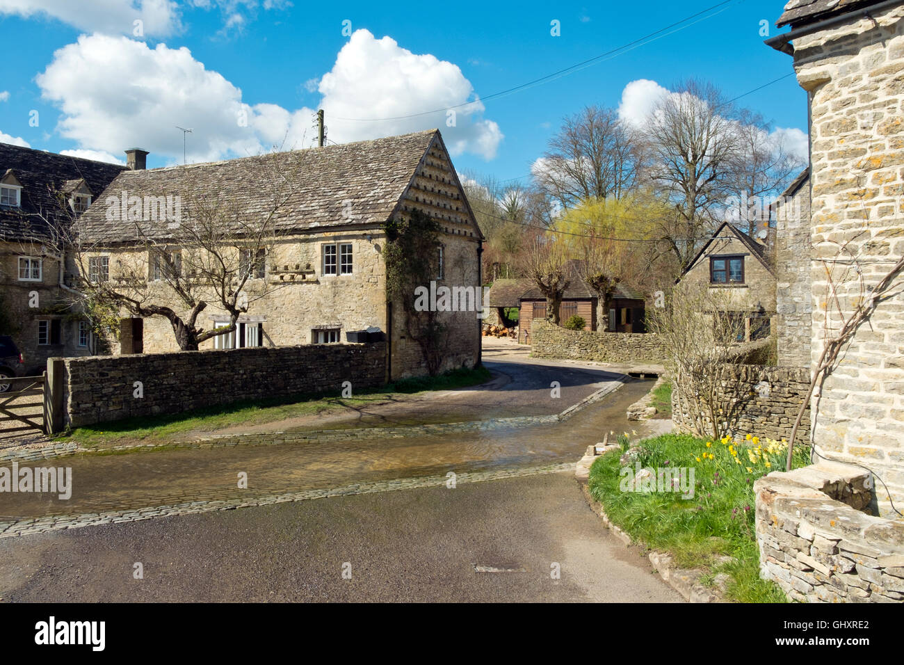 Picturesque Cotswold cottages cluster around the Dunt Stream ford in spring sunshine, Duntisbourne Leer, Cotswolds, Gloucestershire, UK Stock Photo
