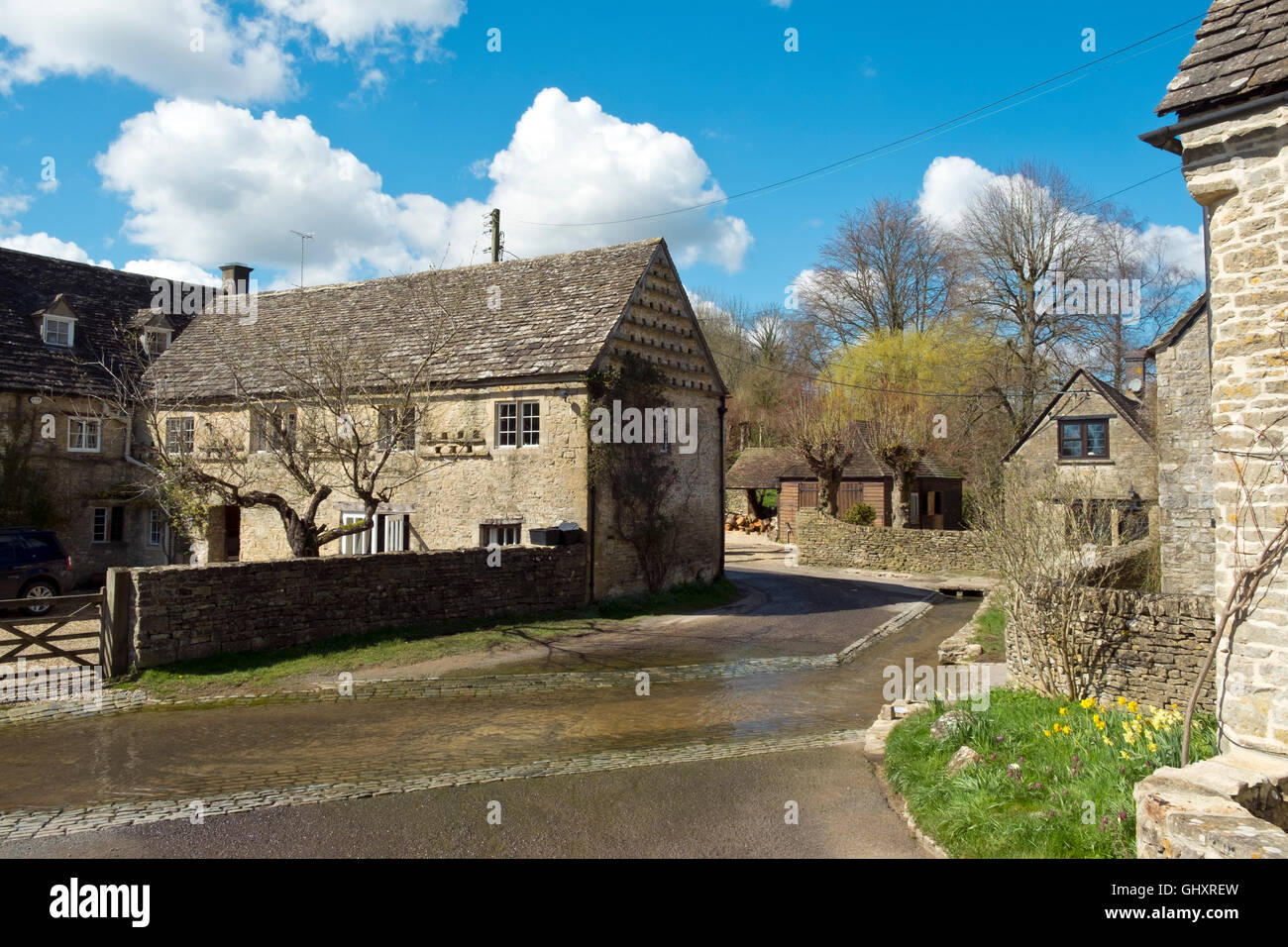 Picturesque Cotswold cottages cluster around the Dunt Stream ford in spring sunshine, Duntisbourne Leer, Cotswolds, Gloucestershire, UK Stock Photo