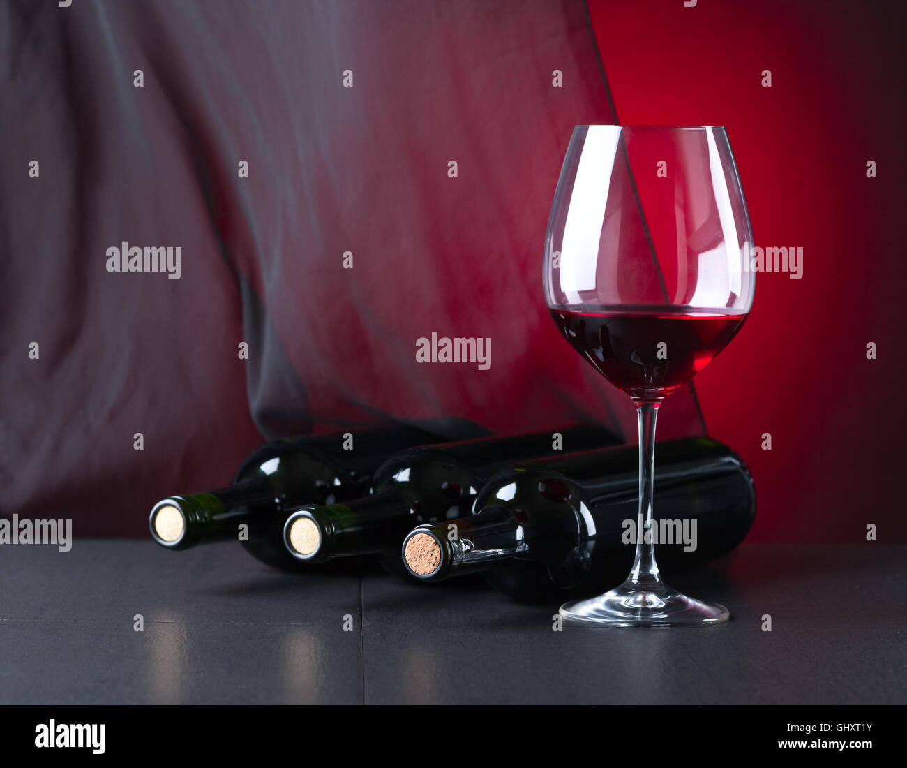 bottles and glass with red wine on black table Stock Photo Alamy