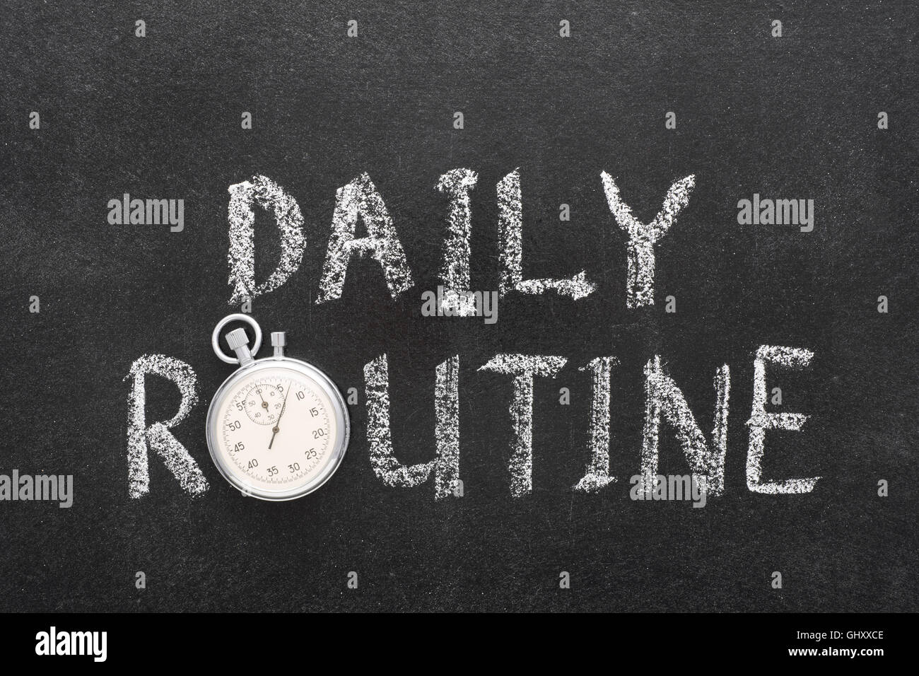 daily routine phrase handwritten on chalkboard with vintage precise stopwatch used instead of O Stock Photo