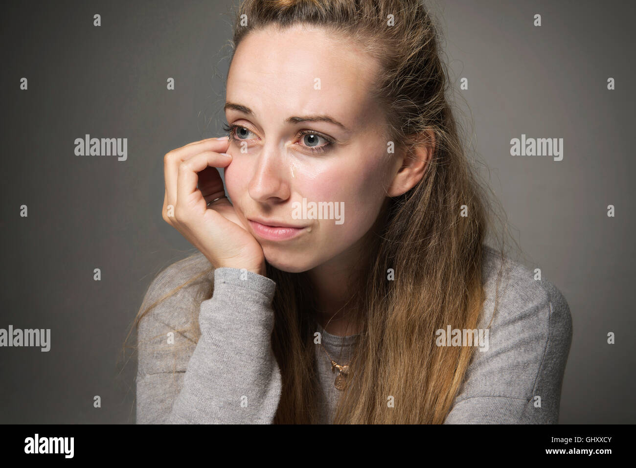 Sad young woman close up tears running down face looking in despair