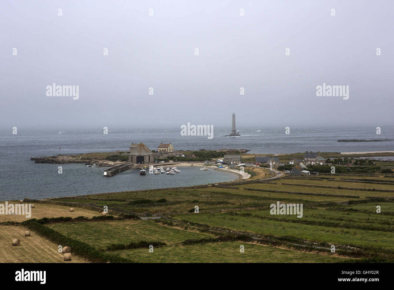 View over the port of Goury in France on a misty morning featuring the lighthouse Stock Photo