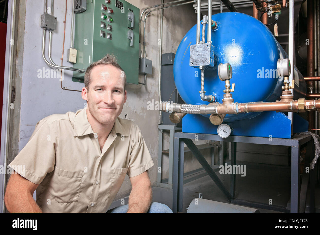 An Air Conditioner Repair Man at work Stock Photo