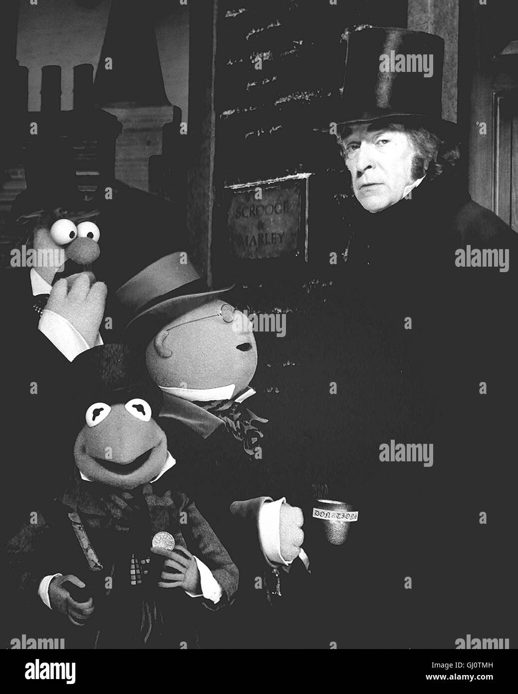 DIE MUPPETS WEIHNACHTSGESCHICHTE London vor 150 Jahren: Der herzlose Geldverleiher Scrooge (MICHAEL CAINE) machts sich auch an Weihnachten durch sein boshaftes Verhalten unbeliebt. plötzlich entführen ihn drei gute Geister in seine einsame Jugend und seine ebenso trostlose Zukunft. Scrooge ist von dieser Offenbarung so gerührt, daß er sich um seinen treuen Buchhalter Bob und dessen kranken Sohn sorgt. Unser Bild: Selbst an Weihnachten bietet Geizkragen Scrooge (MICHAEL CAINE) Spendensammler Beaker, Bunsen Honeydew und Kermit einen frostigen Empfang... Regie: Brian Henson aka. Muppets Stock Photo