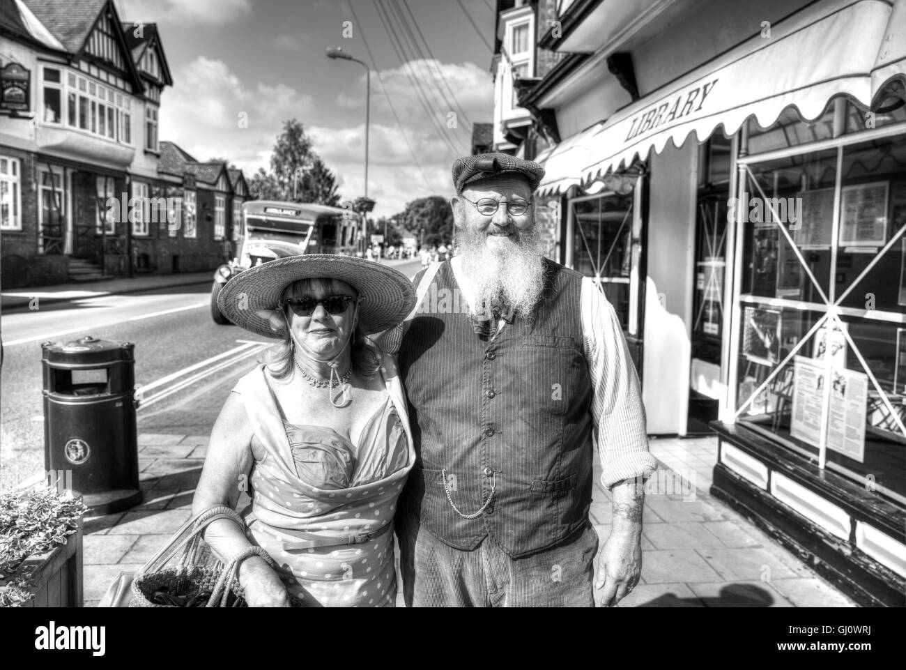 Old fashioned couple flat cap pipe vintage dress attire beard bearded man posing in street UK England GB Stock Photo