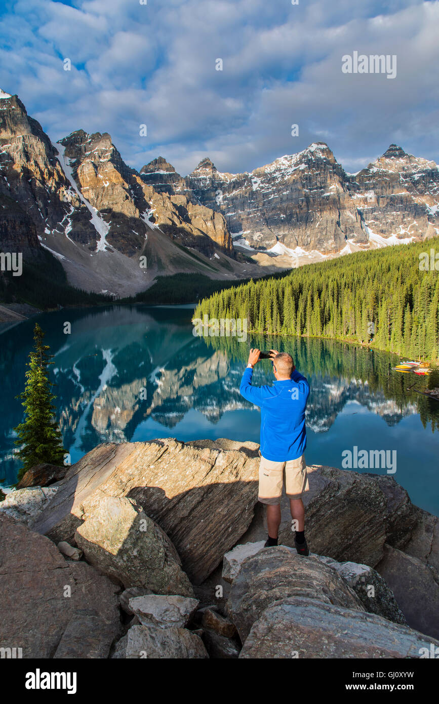 Hiker taking a picture at Moraine Lake, Banff National Park, Alberta, Canada Stock Photo