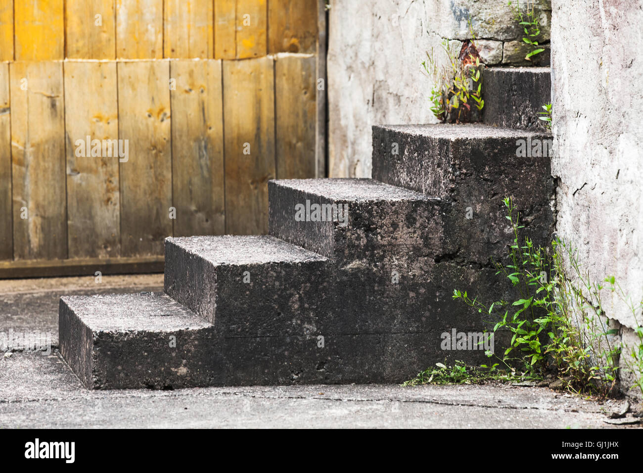 Abstract rural architecture fragment, old concrete stairs near wooden wall Stock Photo