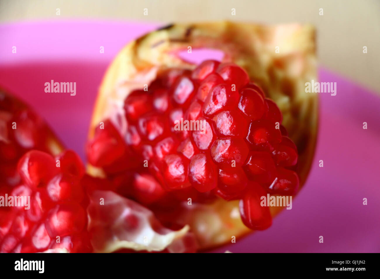 close up, tropical fruits, south india, sweet fruit, edible fruit, pink background, ripe pomegranate fruit, close up, juicy frui Stock Photo
