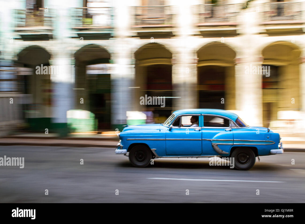 Panning shot of classic, vintage car on sunny day in colonial street, Havana, Cuba, 2013 Stock Photo