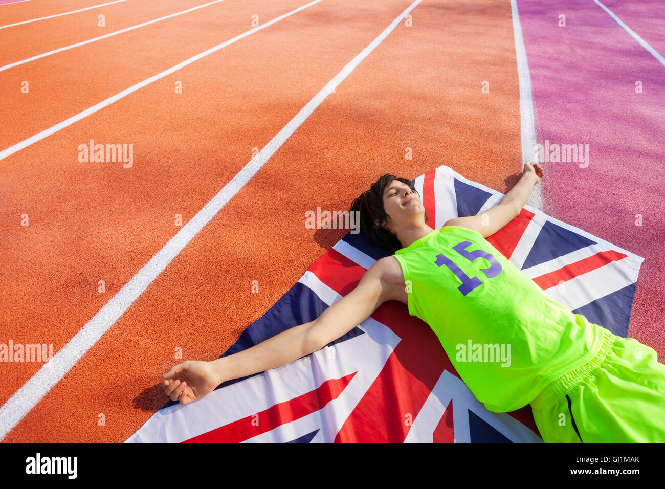 Happy British marathon winner laying on the track Stock Photo