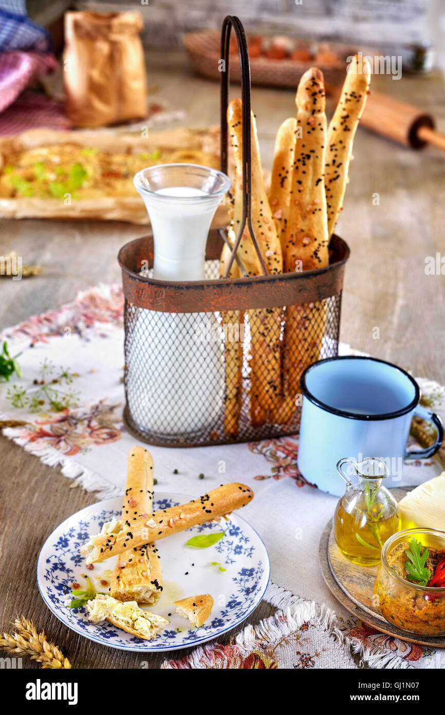 Bread sticks with milk, breakfast rustic setting on a wooden table. Stock Photo