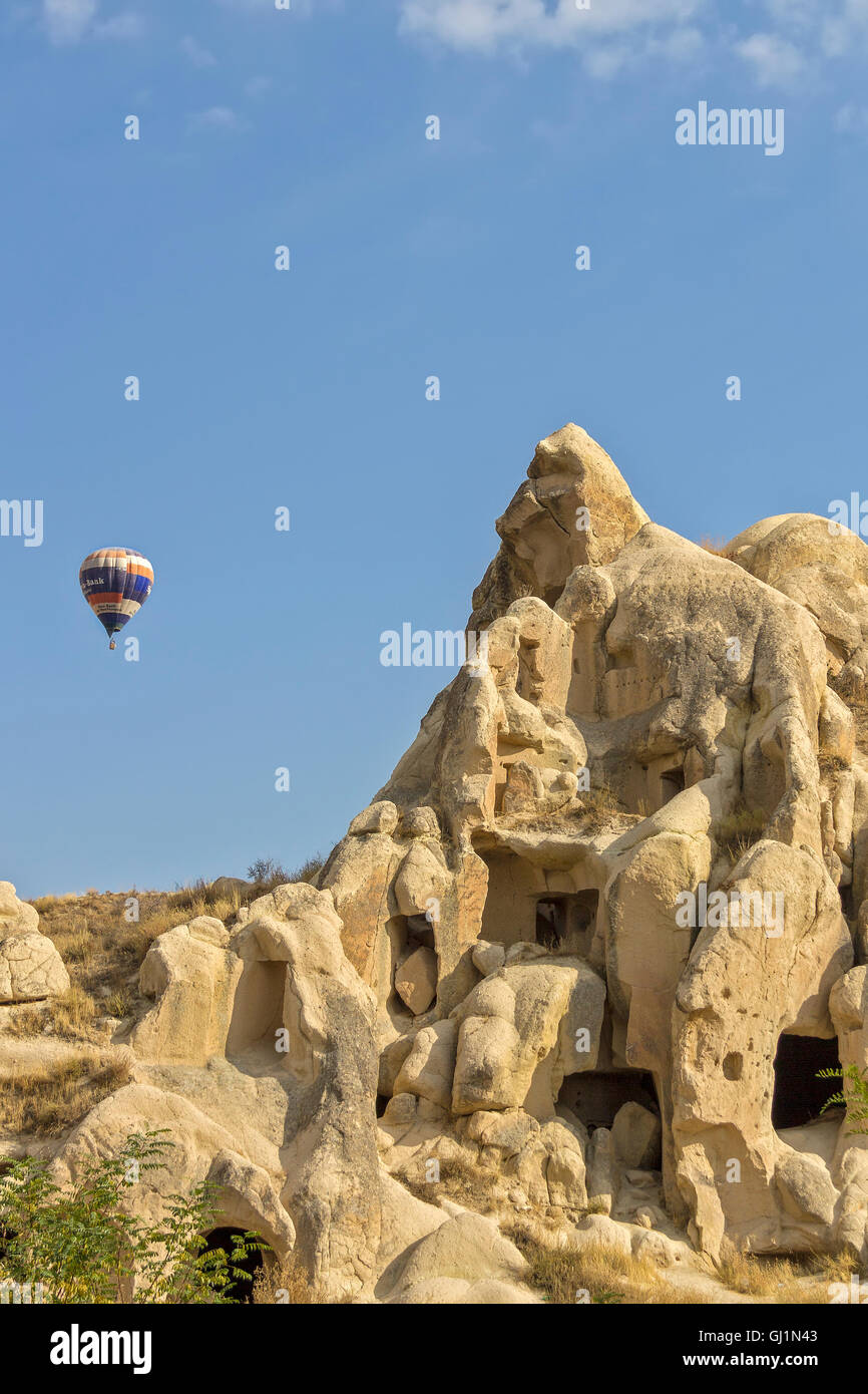 Balloon Over Rock Houses Cappadocia Turkey Stock Photo