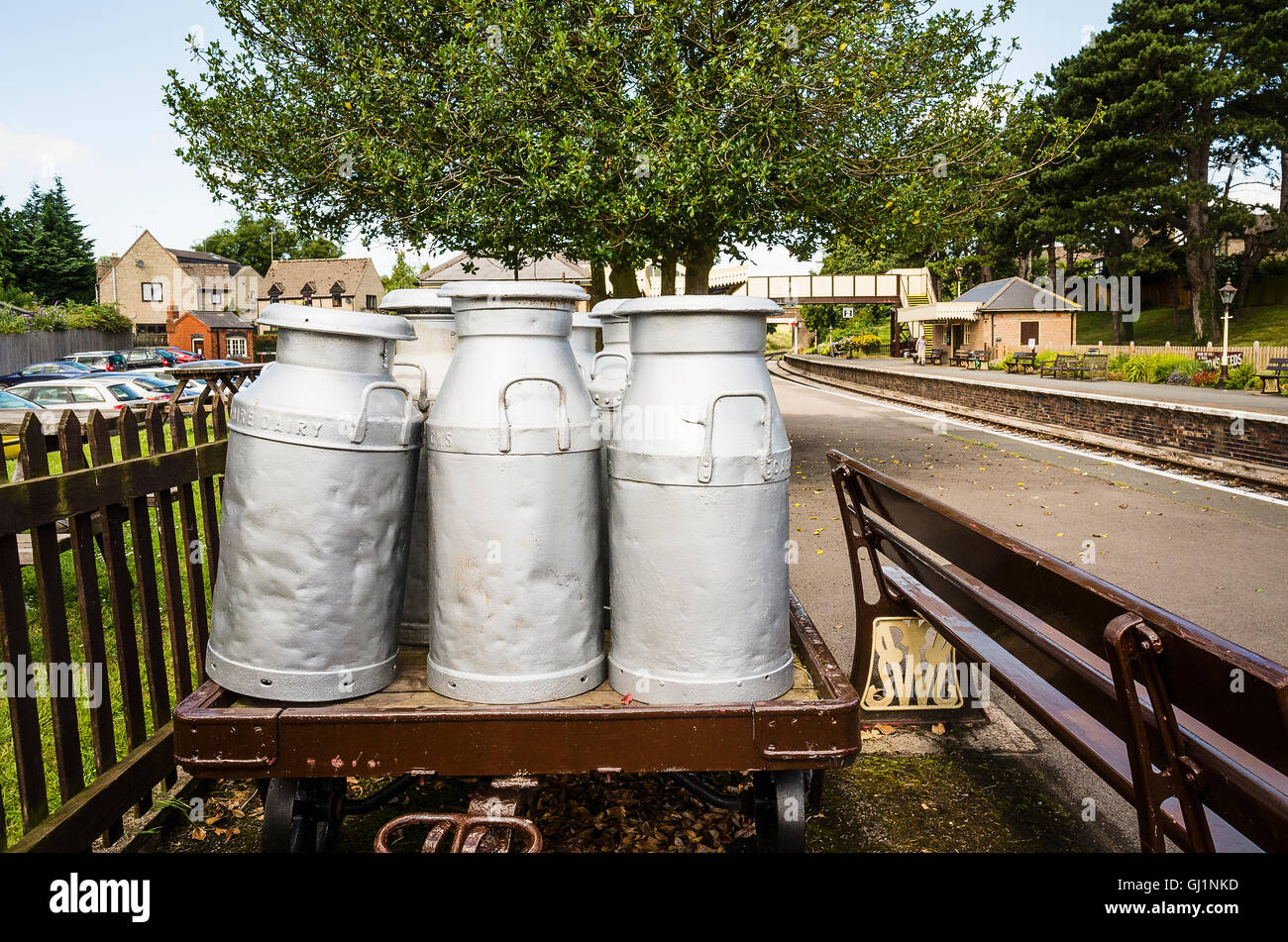 Old milk churns of the type once transported by rail in the UK seen at Winchcombe railway station Stock Photo