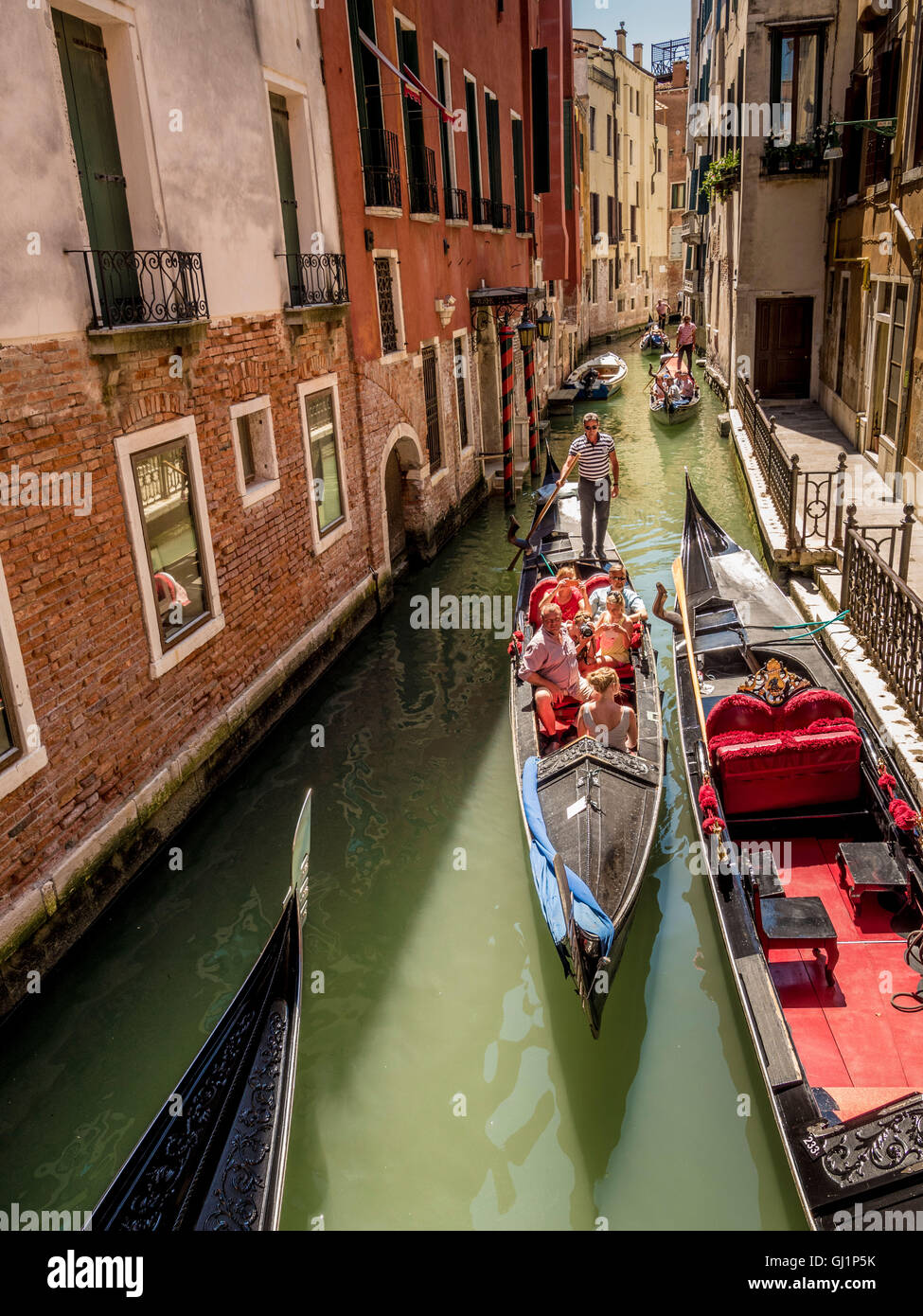 Gondolas passing each other on a narrow, congested canal in Venice, Italy. Stock Photo