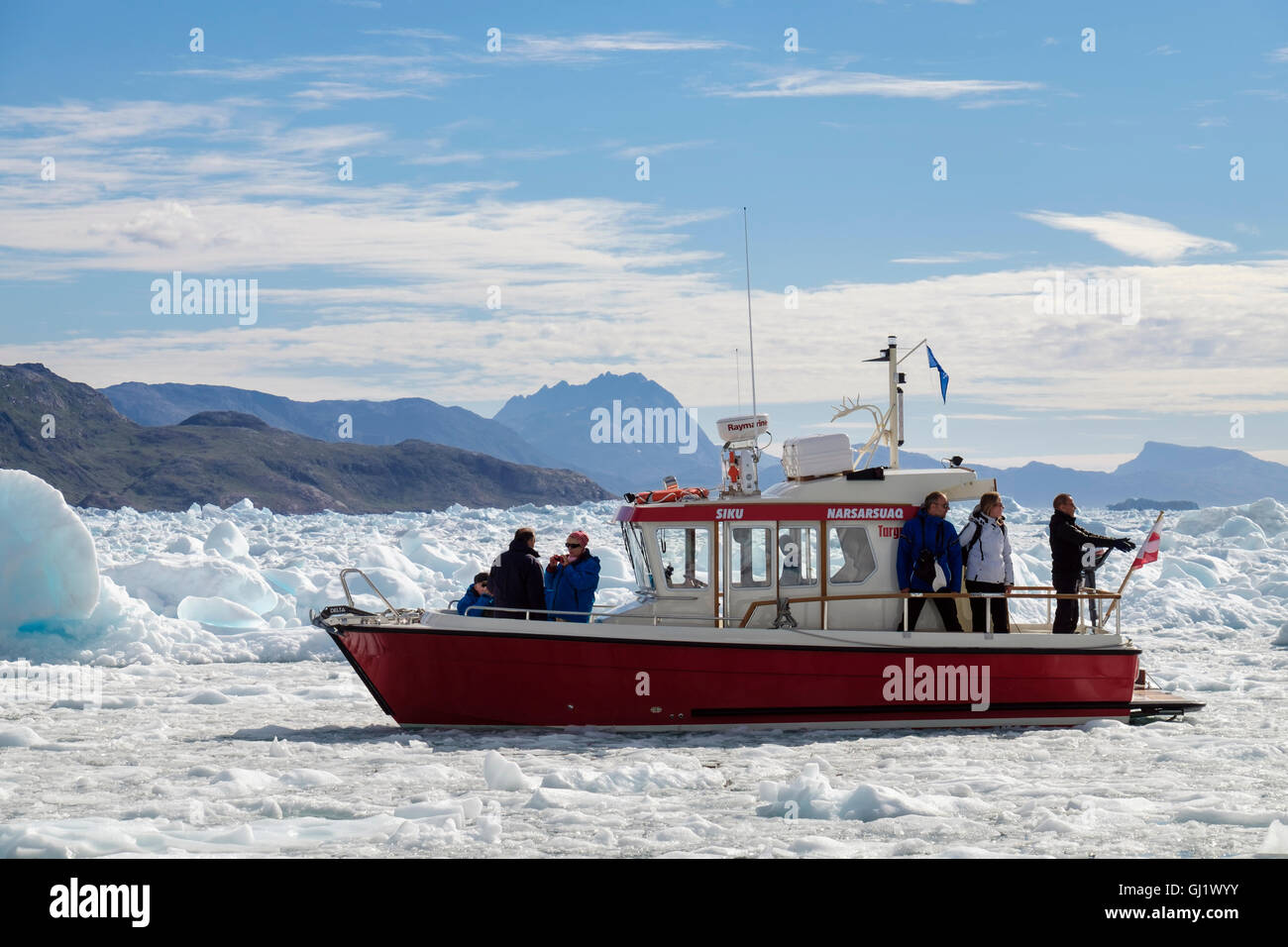 Tourists on boat visiting Qooroq icefjord surrounded by ice floating in Tunulliarfik ice Fjord in summer 2016. Narsarsuaq Southern Greenland Stock Photo