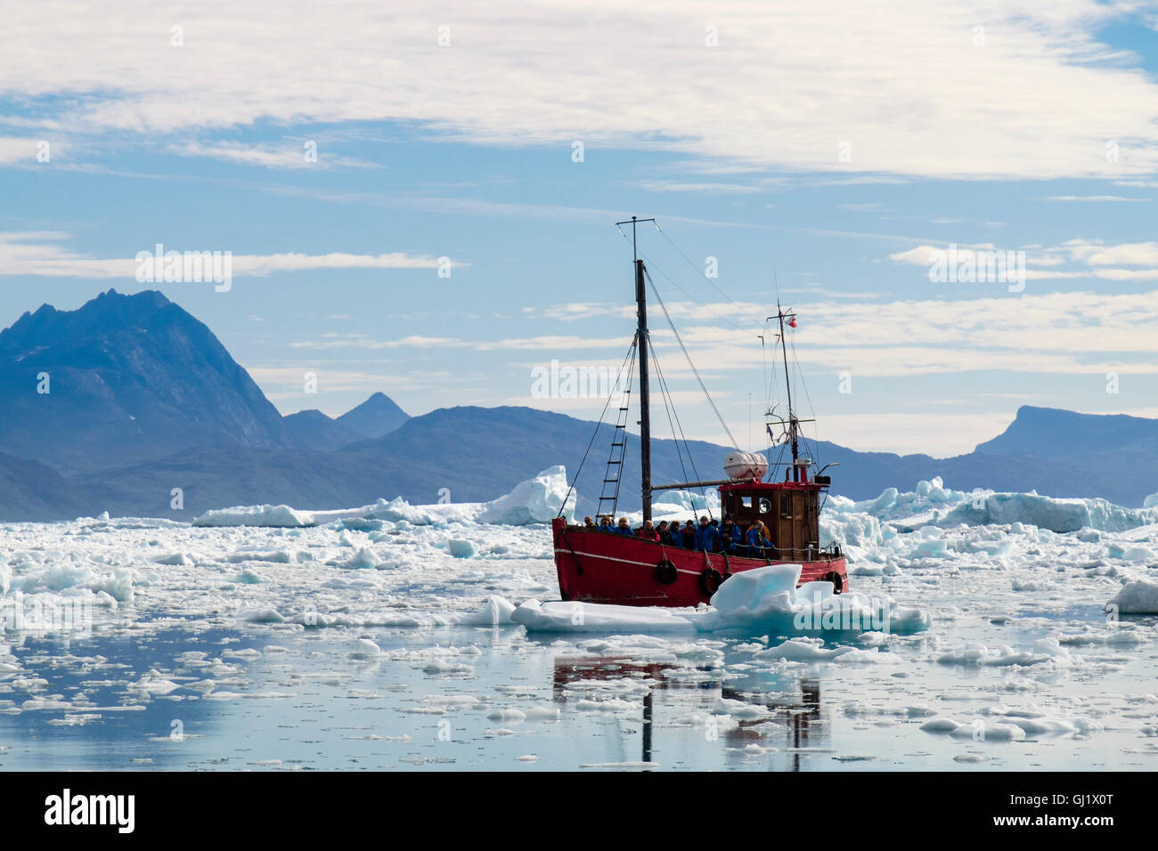 Tourists on old fishing boat visiting icefjord with sea ice and icebergs from Qooroq ice fjord in Tunulliarfik Fjord summer 2016. Narsarsuaq Greenland Stock Photo