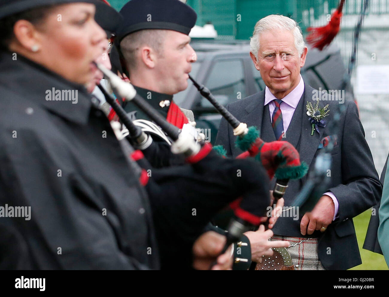 The Prince of Wales, also known as the Duke of Rothesay, watches members of the Ballater and District Massed Pipes and Drums during the Highland Games at Monaltrie Park in Ballater, Aberdeenshire. Stock Photo