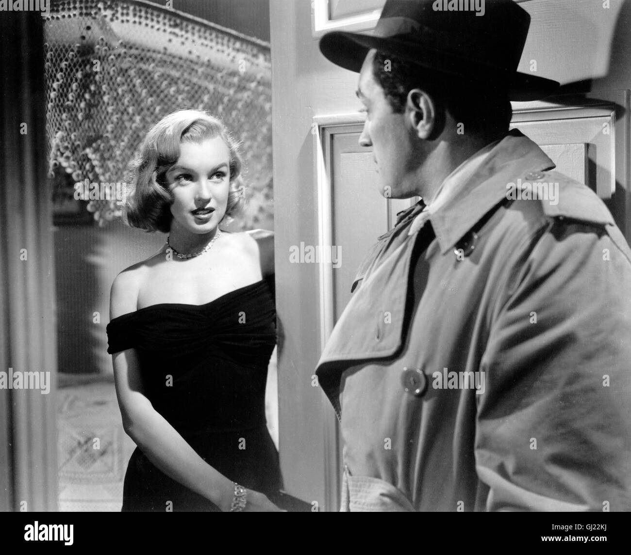 ASPHALT DSCHUNGEL The Asphalt Jungle USA 1950 - John Huston Nach einem raffinierte Juwelenraub versuchen zwei Gangster sich getrennt in Sicherheit zu bringen. Einer wird jedoch von der Polizei gestellt, der andere stirbt auf der Flucht. Nur der eigentliche Drahtzieher, als ehrenwerter Bürger bestens getarnt, kommt ungestraft davon. In John Hustons Kriminalfilm, der erstmals aus der Sicht des Gangsters erzählt wird, ist die damals 23-jährige Marilyn Monroe in einer kleinen, aber bemerkenswerten Rolle zu sehen. Szene mit MARILYN MONROE als Angela Regie: John Huston aka. The Asphalt Jungle Stock Photo