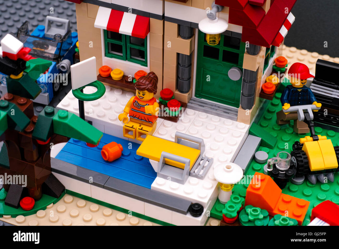 Lego house with pool and backyard. There are Lego girl near pool and man  with lawnmower in backyard Stock Photo - Alamy