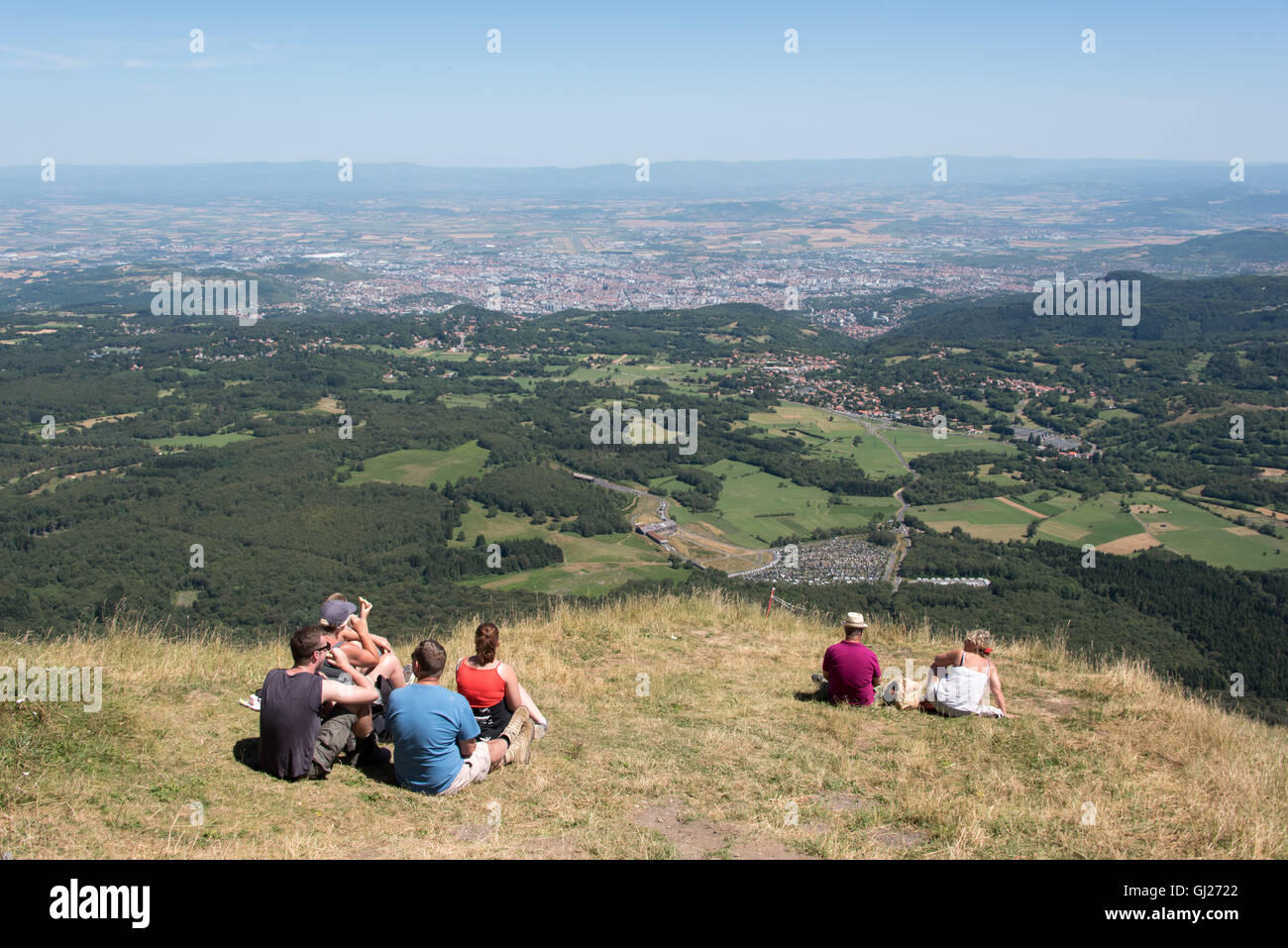 Families sat enjoying the view from the summit of Puy de Dome volcano in the Auvergne region of France Stock Photo