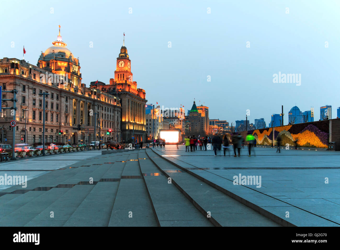 Shanghai, China: March 26, 2016: Day view of the Bund of Shanghai and the bronze bull and some tourists passing by Stock Photo