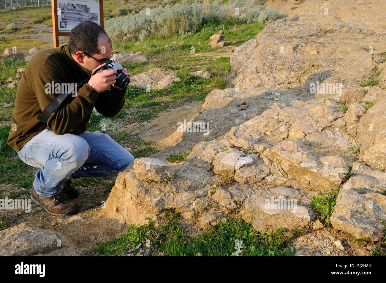 a tourist photographing the archaeological finds of Geopaleosito of Duidduro, Sardinia Stock Photo