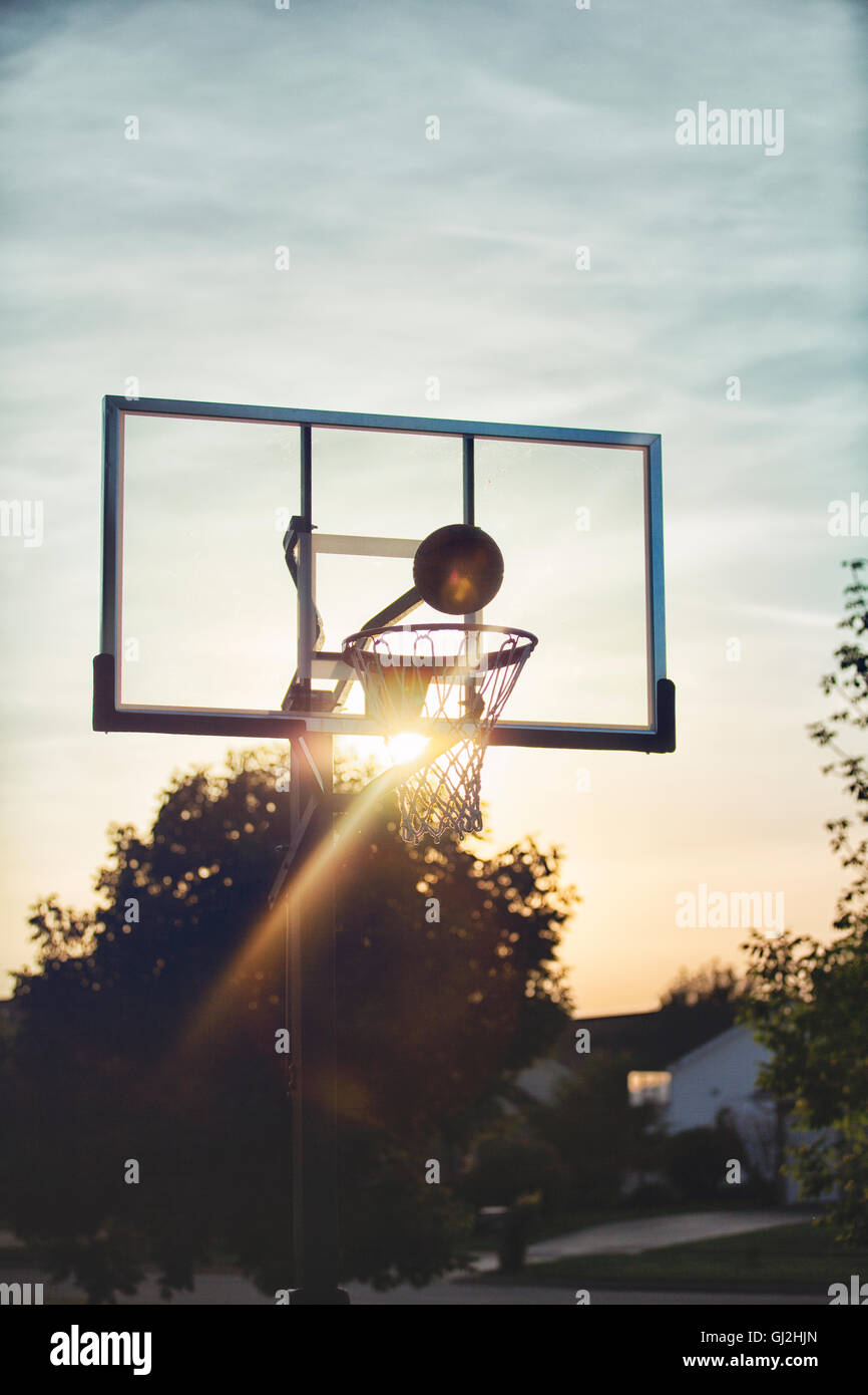 Basketball about to drop through basketball hoop Stock Photo Alamy