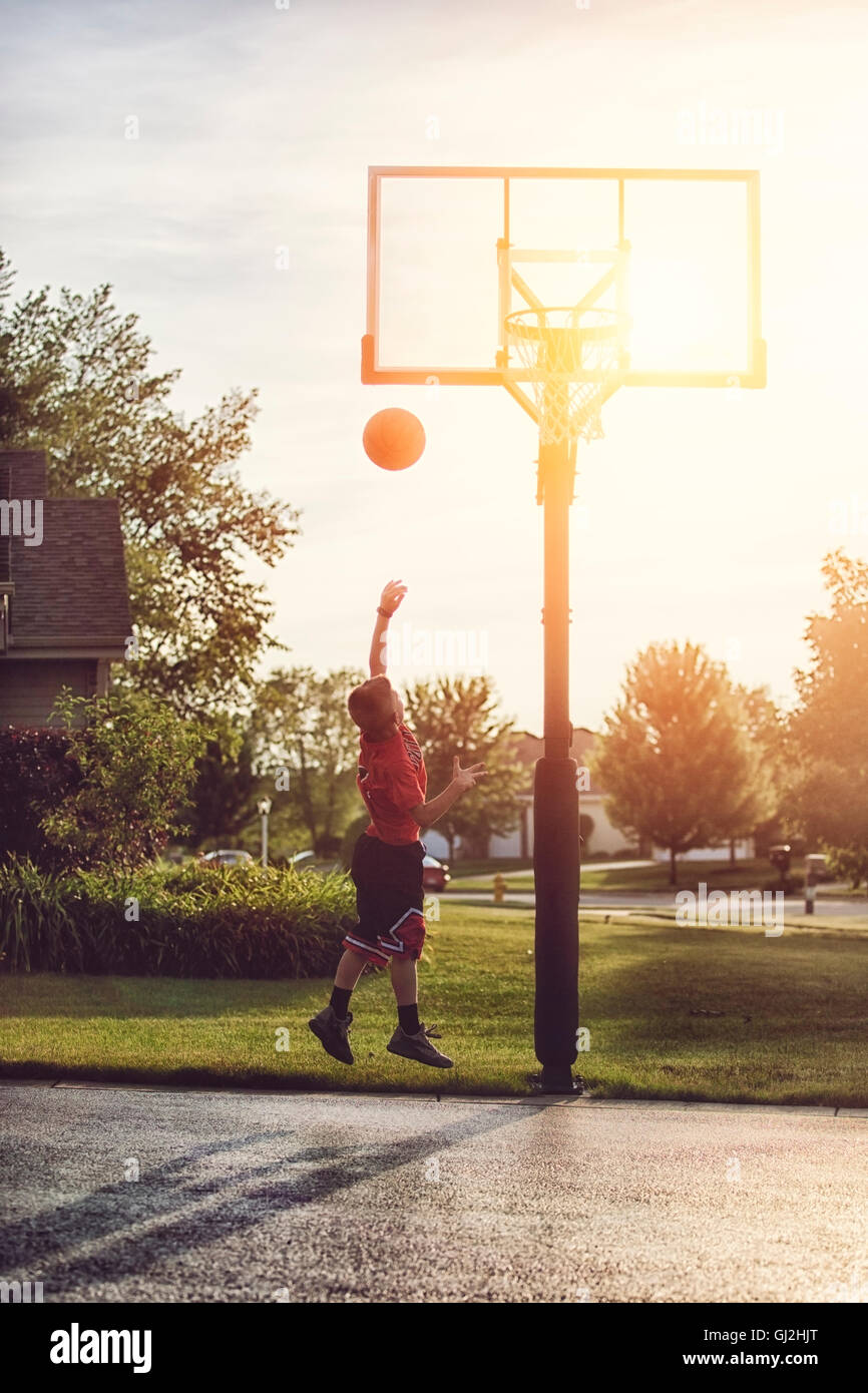 Boy shooting a basketball hook shot Stock Photo