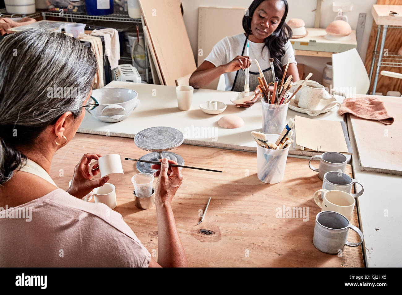 Potters in workshop painting pottery Stock Photo - Alamy