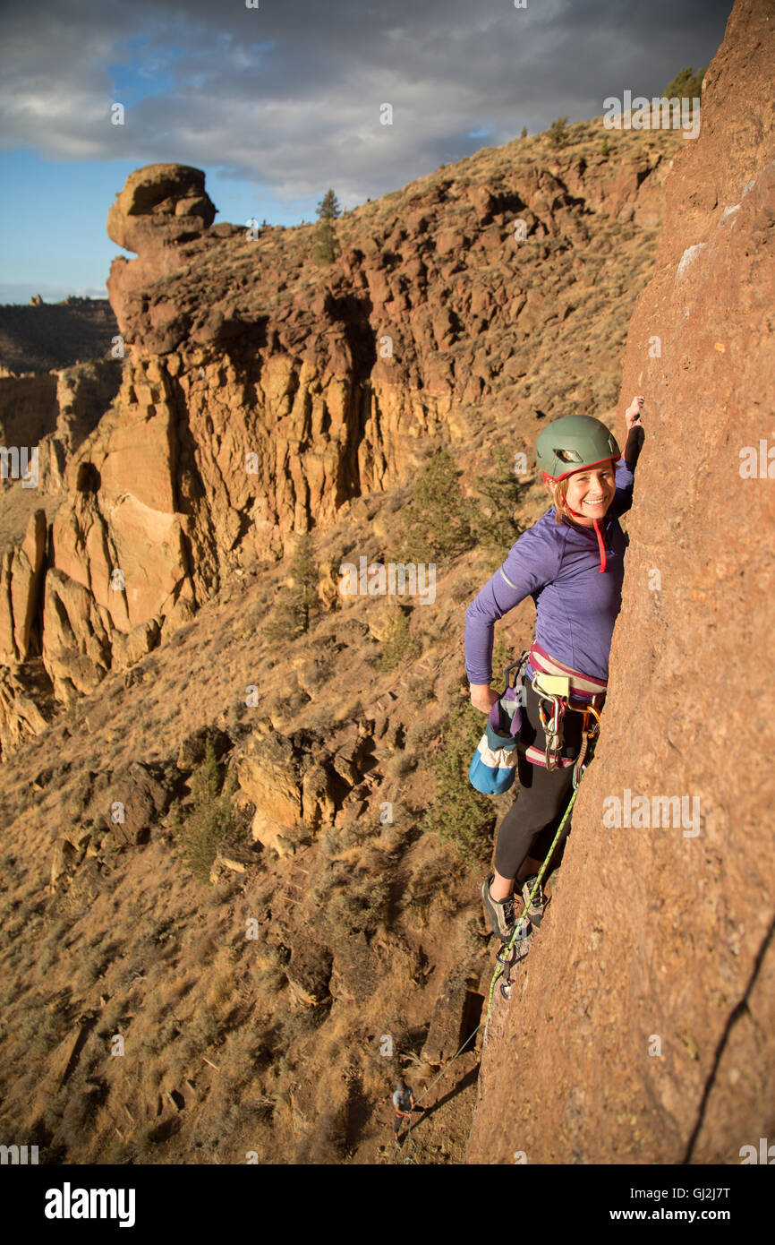 Woman rock climbing looking at camera smiling Stock Photo Alamy