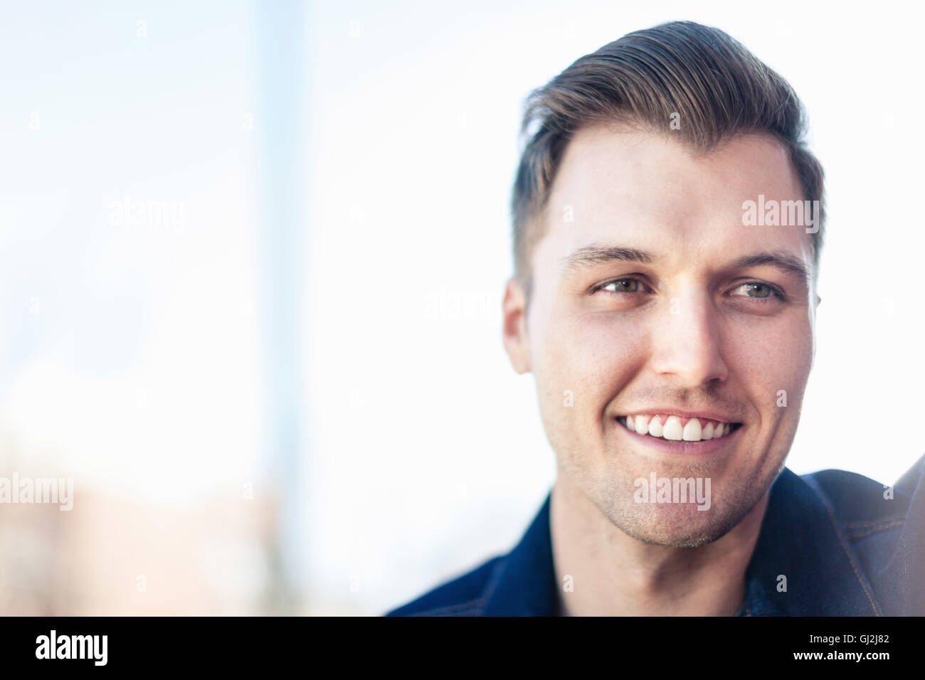 Portrait of smiling young man looking away Stock Photo