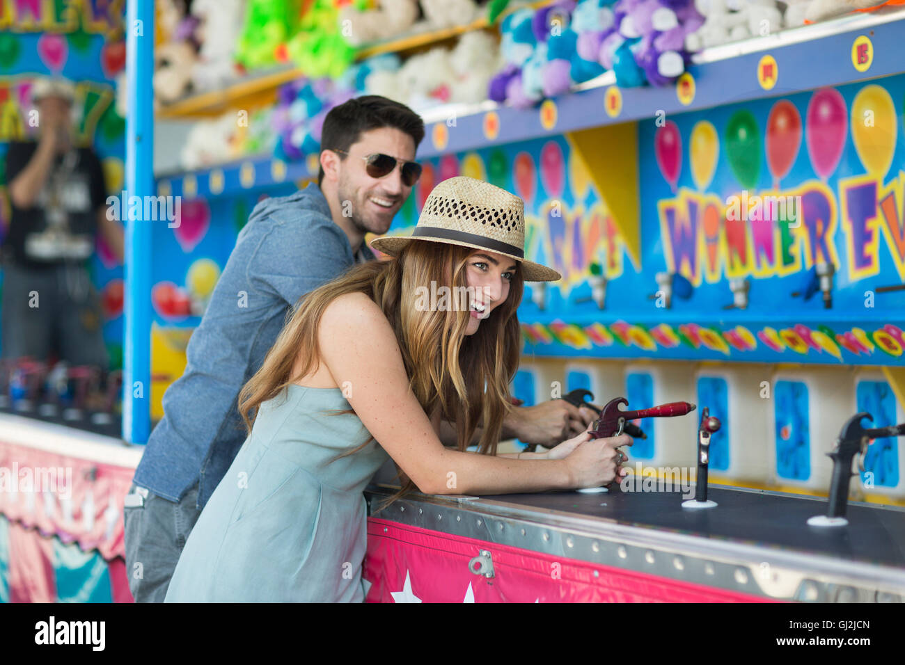 Couple at fairground shooting gallery, Coney island, Brooklyn, New York