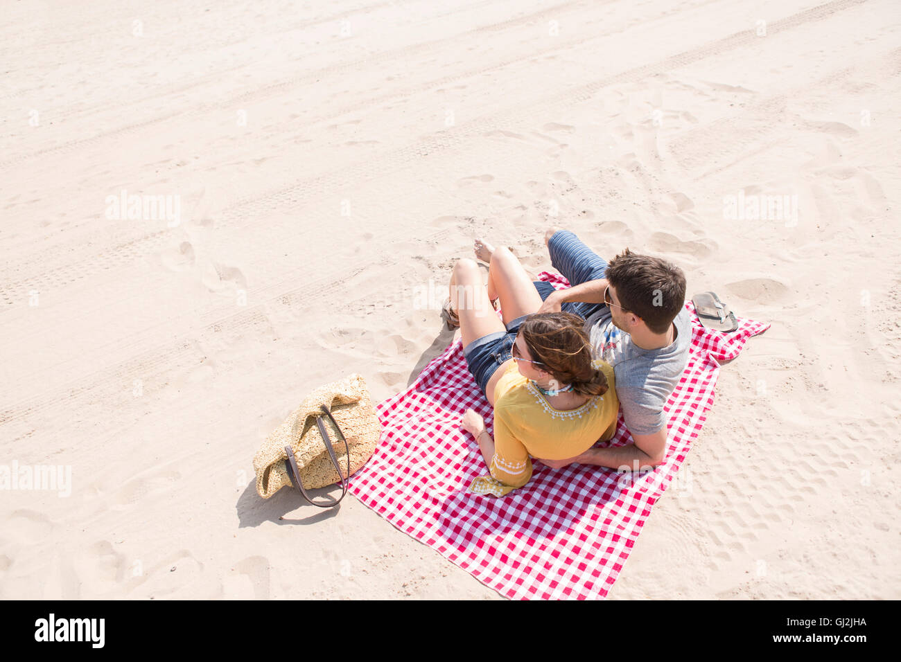 Couple lying on picnic blanket on beach, Coney island, Brooklyn, New