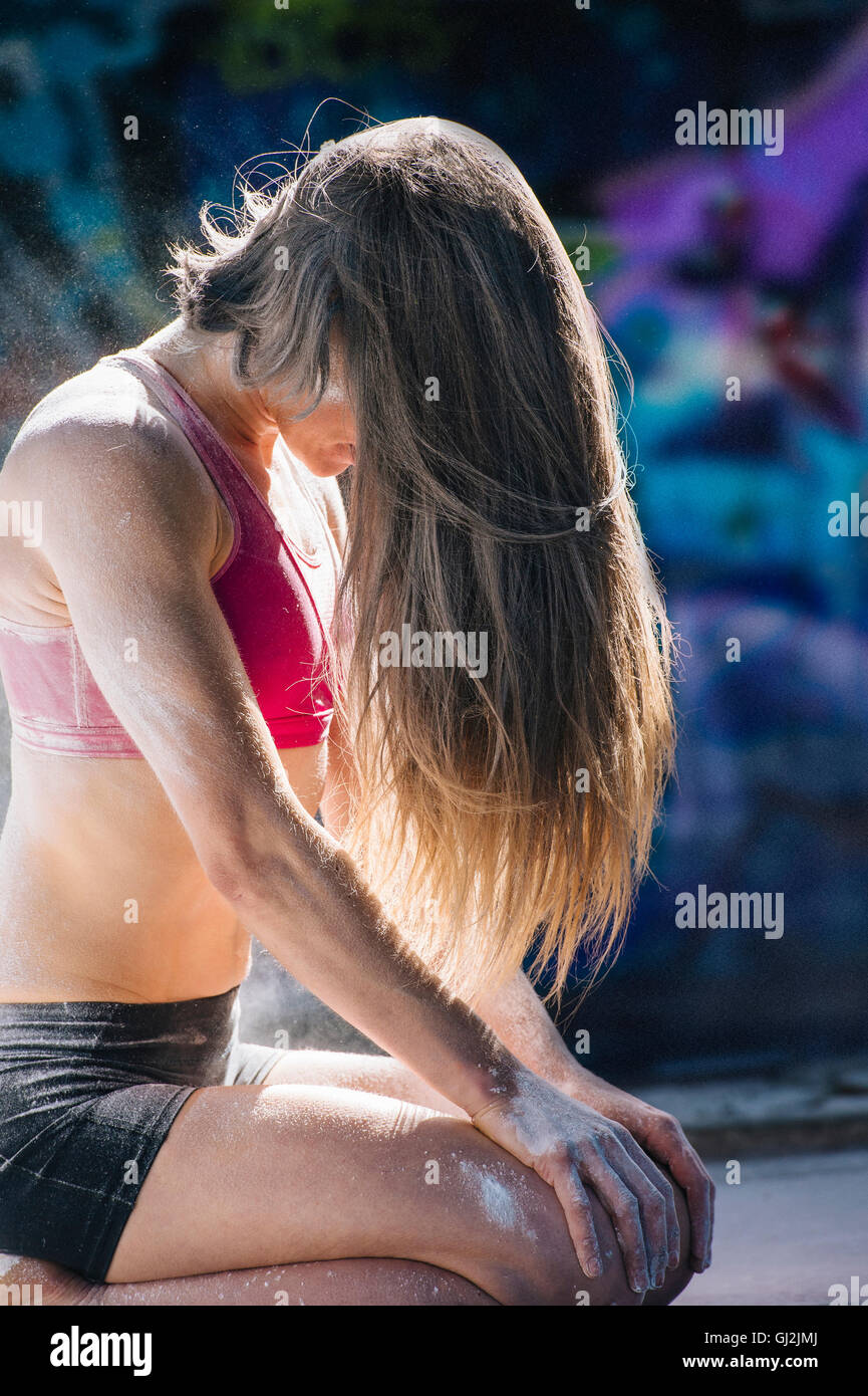Woman kneeling, hair covering face Stock Photo