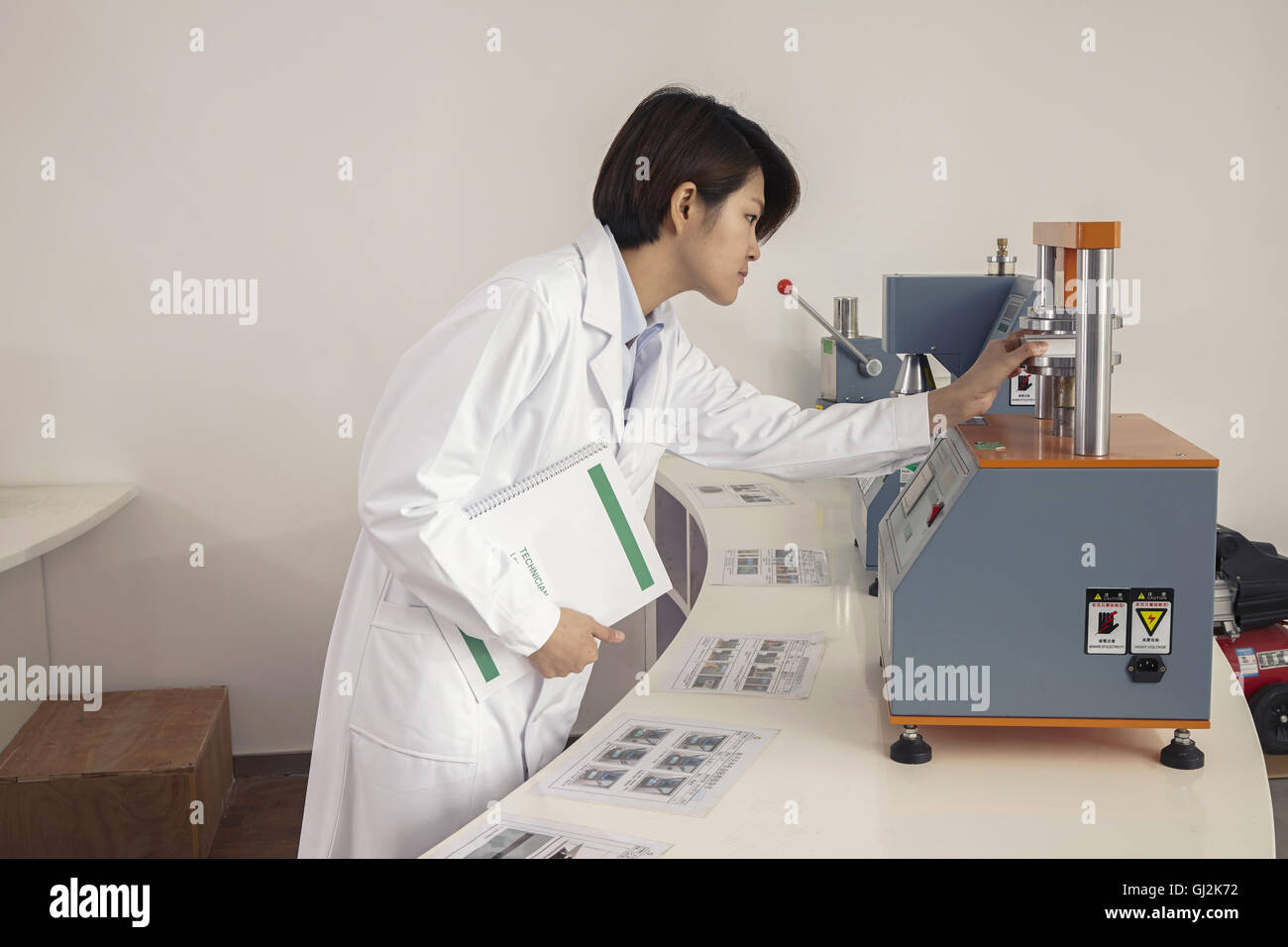 Female technician operating printing machine in printing and packaging factory, China Stock Photo