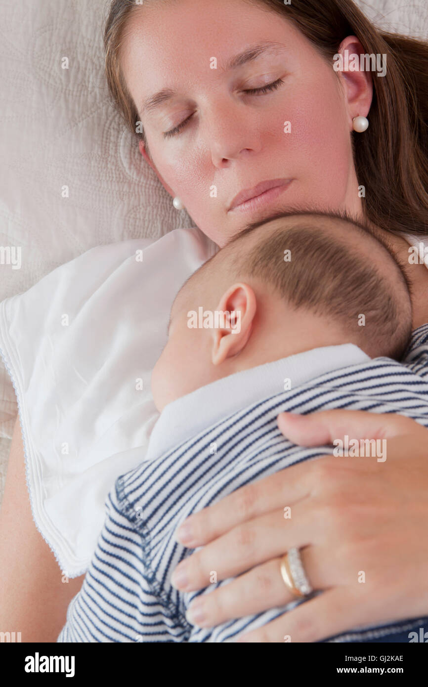 Baby boy sleeping on mothers chest Stock Photo
