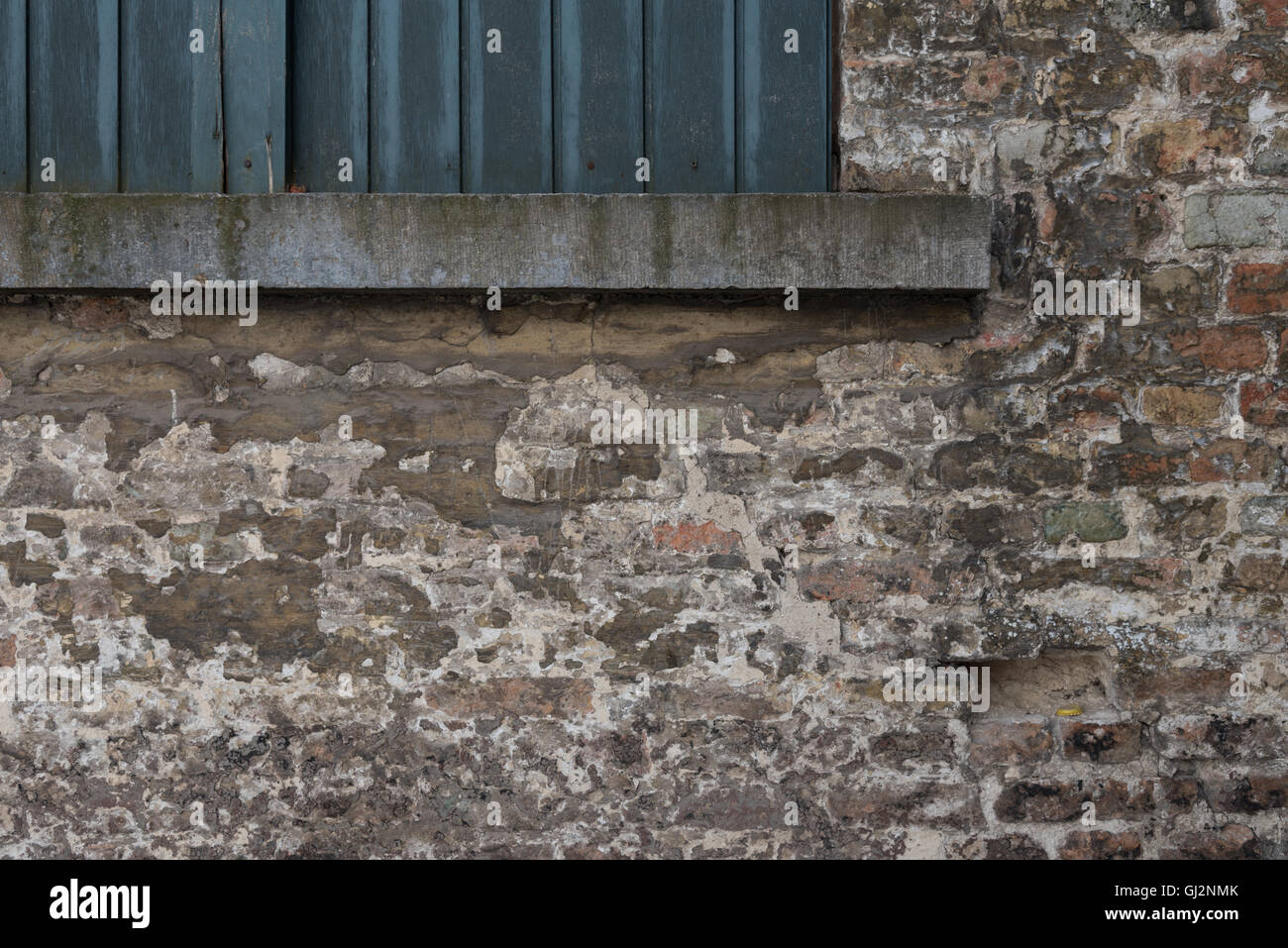Distressed weathered brick wall detail in Bruges. Stock Photo