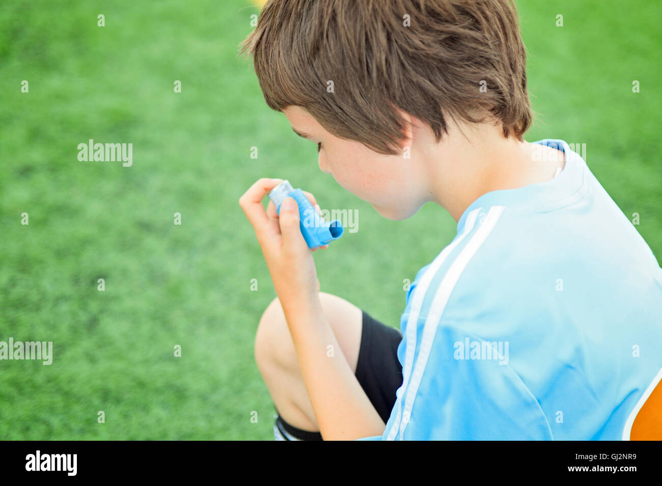 A young soccer player taking his asthma inhalator Stock Photo Alamy