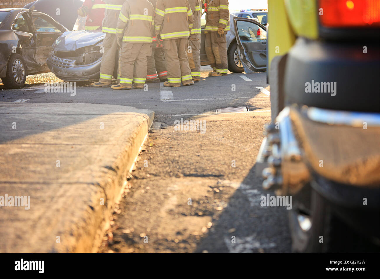 An accident scene on the road of a city with ambulance and fire fighter ...