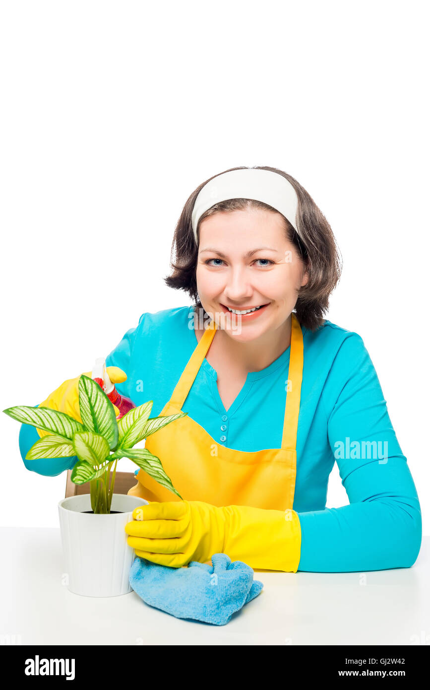 beautiful housewife takes care of a flower in a pot on a white